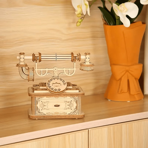 Maquette téléphone ancien en bois posée sur meuble salon, objet décoratif style rétro chic avec cadran et tiroir ornemental